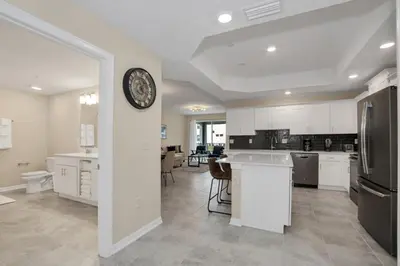 a kitchen with white cabinets and a clock on a wall at 3 BR 2 BA Deluxe Condo 8min to Disneyworld STL105 in Kissimmee