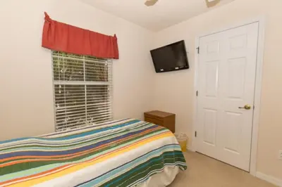 a bedroom with a bed and a flat screen tv at Peaceful Quiet Pool Home 5 min from Disney! townhouse in Orlando