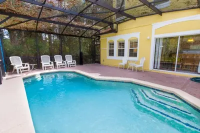 a swimming pool with chairs and a house at Peaceful Quiet Pool Home 5 min from Disney! townhouse in Orlando
