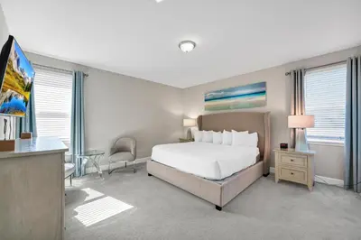 a bedroom with a bed and a desk and a tv at Alluring Home With Private Pool And Waterpark & Resort Access Near Disney At Encore Resorts Reunion - 280Sf in Kissimmee
