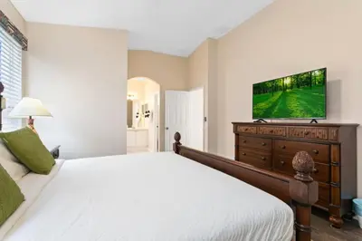a bedroom with a bed and a television on a dresser at South Facing Pool 4 Bedroom 3 Bath Villa villa in Kissimmee