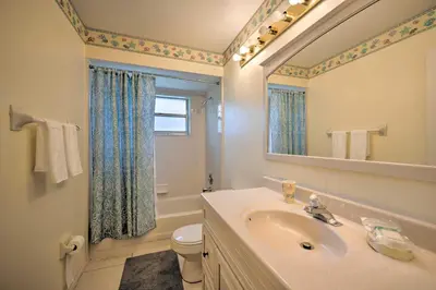 a bathroom with a sink and a toilet and a mirror at about 5 Mi to Theme Parks Kissimmee Home with Pool in Orlando