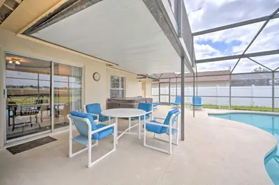 a patio with a table and chairs and a pool at about 5 Mi to Theme Parks Kissimmee Home with Pool in Orlando