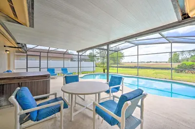 a patio with a table and chairs and a pool at about 5 Mi to Theme Parks Kissimmee Home with Pool in Orlando