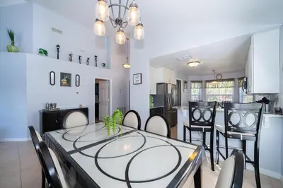 a dining room and kitchen with a table and chairs at South Facing Pool with Stunning Lake View - Family Friendly Home - Nr Disney in Kissimmee