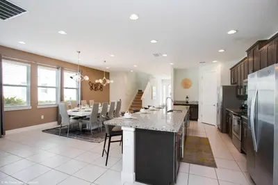 a large kitchen with a table and a dining room at Stylish Family Home Private Pool/Spa 10min Disneyworld Sleeps 22 in Orlando