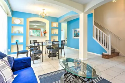 a living room with blue walls and a table and chairs at Less Than 5 Mi to Disney World Resort Home for Families! in Kissimmee
