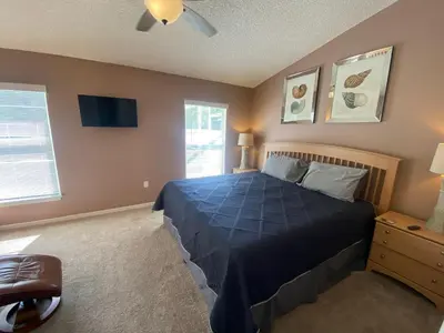 a bedroom with a blue bed and a window at 3 Bedroom Villa with Poolside Cinema and Games Room Close to theme Parks sleeps 6 in Orlando