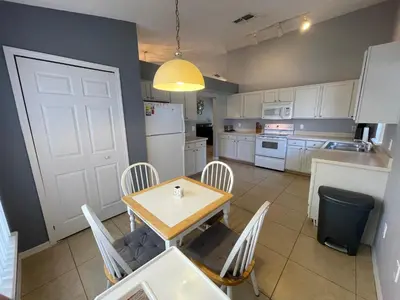 a kitchen with a table and chairs and a white door at 3 Bedroom Villa with Poolside Cinema and Games Room Close to theme Parks sleeps 6 in Orlando