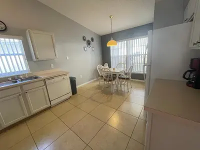 a kitchen and dining room with a table and chairs at 3 Bedroom Villa with Poolside Cinema and Games Room Close to theme Parks sleeps 6 in Orlando
