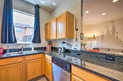 a kitchen with wooden cabinets and a sink and a window at Disney-Inspired Townhome with Private Hot Tub! in Orlando