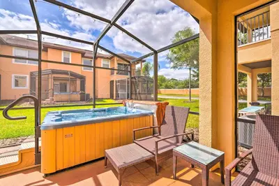 a hot tub on a patio with a table and chairs at Disney-Inspired Townhome with Private Hot Tub! in Orlando