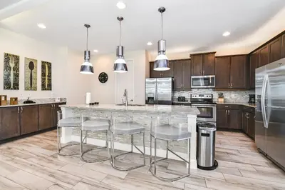 a kitchen with a large island with bar stools at Utopic Home With Themed Rooms, Game And Media Room And Waterpark & Resort Access Near Disney At Encore Resorts Reunion - 270Cl in Kissimmee