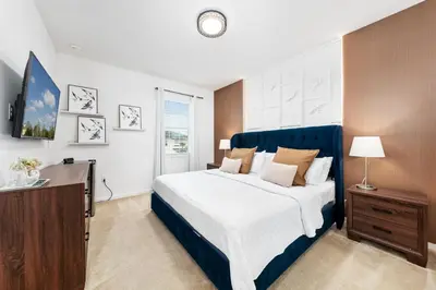 a bedroom with a large bed with a blue headboard at Fresh Amazing Family Home. Private Pool. Game Room. Sleeps 24 in Kissimmee