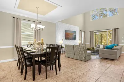 a dining room and living room with a table and chairs at Fun Family Villa Pool BBQ Near Disney World 5BR in Kissimmee