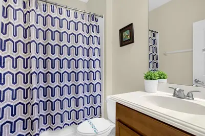 a bathroom with a toilet and a shower curtain at Fun Family Villa Pool BBQ Near Disney World 5BR in Kissimmee