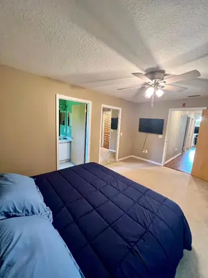 a bedroom with a blue bed and a ceiling fan at Grand Villas of Island 3BR Condo near Disney Parks and Universal in Kissimmee