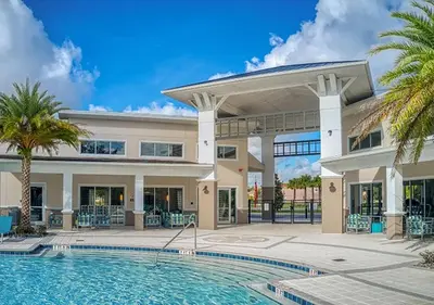 a large house with a swimming pool and palm trees at Upstay 9BR Disney Retreat w Pool, BBQ & Hot Tub in Kissimmee