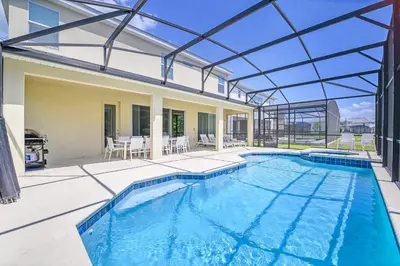an indoor swimming pool with a glass roof at Upstay 9BR Disney Retreat w Pool, BBQ & Hot Tub in Kissimmee