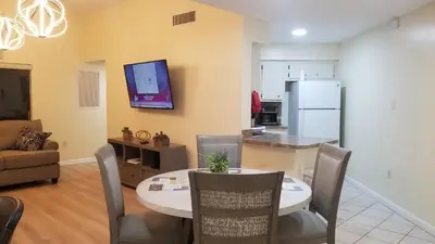a living room with a dining room table and a kitchen at 3648 Orlando Vacational Apartment in Orlando