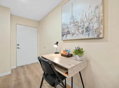a room with a desk with a lamp and a painting on the wall at 3648 Orlando Vacational Apartment in Orlando