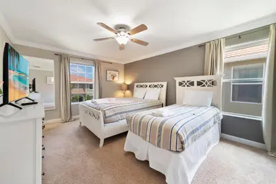 a bedroom with two beds and a flat screen tv at Paradise Villa Disney Staycation Pool, Fun & Resort Access in Kissimmee