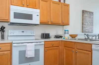 a kitchen with white appliances and wooden cabinets at 133 Beautiful home with lake view in Kissimmee