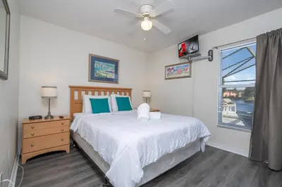 a bedroom with a bed with a ceiling fan and a window at 133 Beautiful home with lake view in Kissimmee