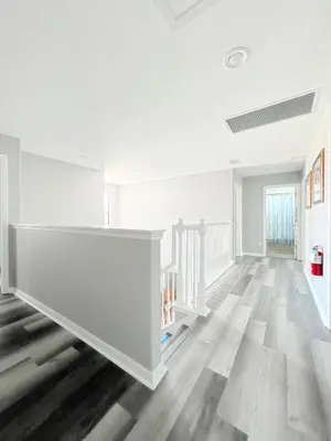 an empty living room with white walls and wood floors at Gone 2 Florida Vacation Homes in Orlando