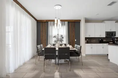 a dining room with a table and chairs and a kitchen at Sophisticated 6BR at Storey Lake SL2766 in Kissimmee
