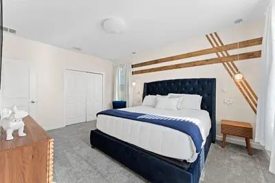a bedroom with a blue and white bed and a wooden table at Sophisticated 6BR at Storey Lake SL2766 in Kissimmee