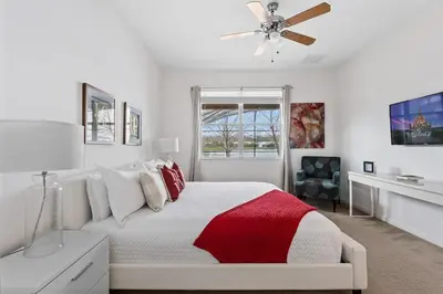 a white bedroom with a bed and a ceiling fan at Ground Floor Gathering up to 9 guests BL387 in Kissimmee