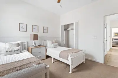 a white bedroom with two beds and a mirror at Ground Floor Gathering up to 9 guests BL387 in Kissimmee