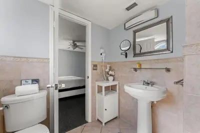 a bathroom with a toilet and a sink and a mirror at Enjoy Disney 3BRs at Villas of Somerset VS2745 in Kissimmee