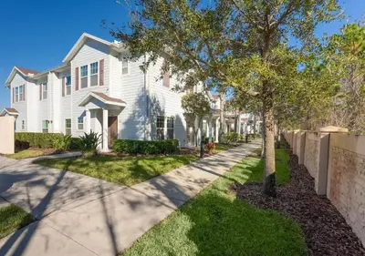 a white house with a tree and a sidewalk at Cozy Decor 4BR at West Lucaya Resort WL8972 in Kissimmee