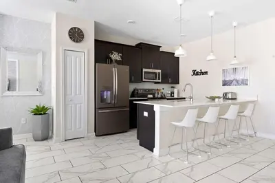 a kitchen with a refrigerator and a counter with bar stools at Disney Familly Lovers up to 11 SL4928 in Kissimmee