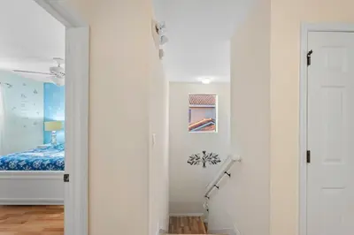 a white hallway with a bed and a staircase at 4BR Townhome with Lake View – BL481 in Kissimmee