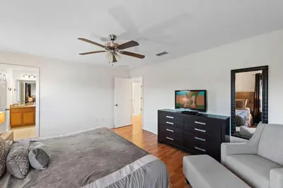 a bedroom with a bed and a couch and a mirror at 4BR Townhome with Lake View – BL481 in Kissimmee