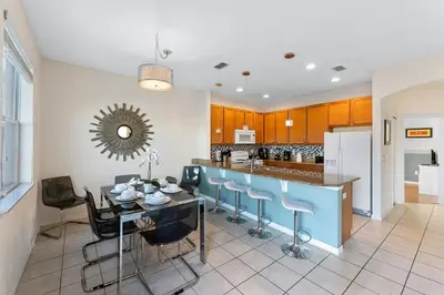 a kitchen with a table and some blue stools at 4BR Townhome with Lake View – BL481 in Kissimmee
