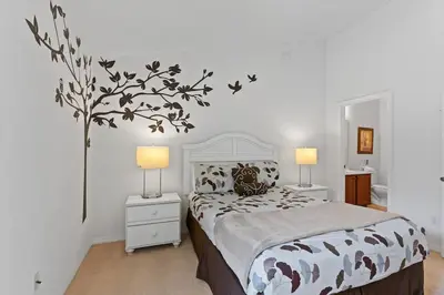 a bedroom with a bed with a tree on the wall at Ground floor spacious house 4BR VP2512 in Kissimmee