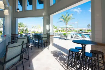 a restaurant with tables and chairs and a pool at 4 BR Bright Cozy at Storey Lake SL3113 in Kissimmee