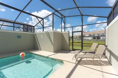 a swimming pool with two chairs and a glass house at Family Friendly Home 4BR Private Pool SL4823 in Kissimmee