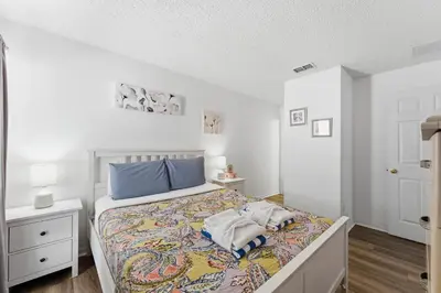 a white bedroom with a bed with blue pillows at 4 BR No carpet Just Remodeled Unit SR1205 in Kissimmee