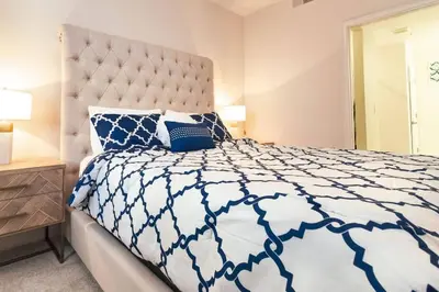 a bedroom with a bed with a blue and white comforter at 2 BR Modern Apt near Disney SL4741 in Kissimmee