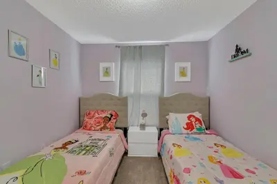 a bedroom with two beds and a window at Disney Themed House Free Heated Pool close Disney 5br 9bd in Orlando
