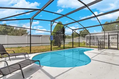 a swimming pool in a glass house with a patio and chairs at Disney Themed House Free Heated Pool close Disney 5br 9bd in Orlando