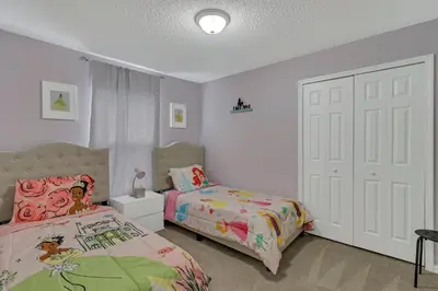 a bedroom with two beds and a white door at Disney Themed House Free Heated Pool close Disney 5br 9bd in Orlando
