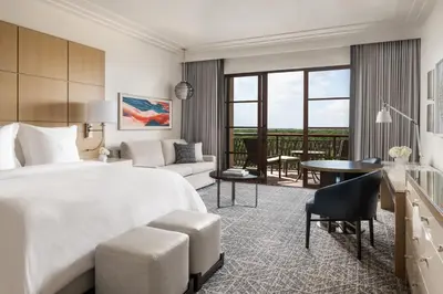 a bedroom with a large bed and a living room at Four Seasons Resort Orlando at Walt Disney World Resort in Orlando