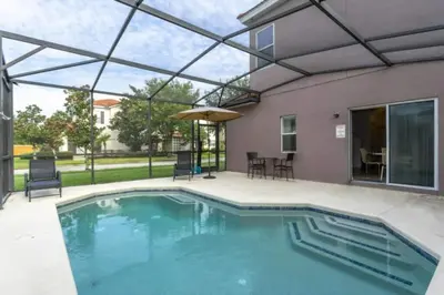 a swimming pool with a patio and a house at 4572 Perfect home for your family close to all parks in Kissimmee