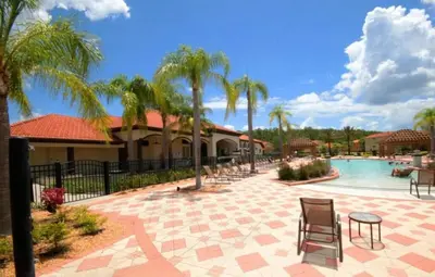 a resort with a pool and chairs and palm trees at 4572 Perfect home for your family close to all parks in Kissimmee